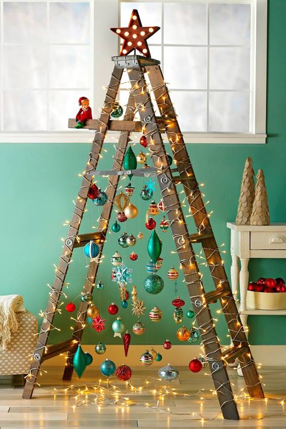  26 a fun Christmas tree of a laddder and colorful ornaments plus lights and a shiny star on top