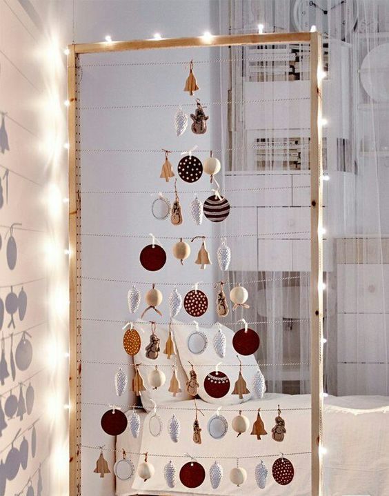  27 take a large frame hang some yarn and form a Christmas tree of your favorite ornaments line it up with lights