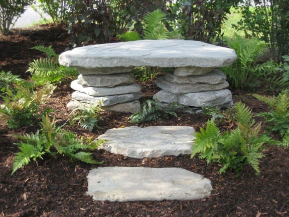 Скамья из камней в саду пейзажного дизайна